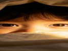 拍孩子躲在被窝里露眼睛，用“手电筒补光”